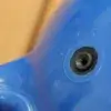 Close-up of a blue "Boat Bumpers (Inflatable)" from Great Northern Docks, with a small black hole and two raised dots; tan background blurred.