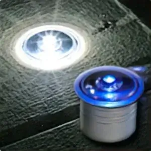 Dock Dots (4 Pack) LED puck lights cast white and blue hues on a textured Aluminum Dock surface, with one glowing nearby for added illumination.