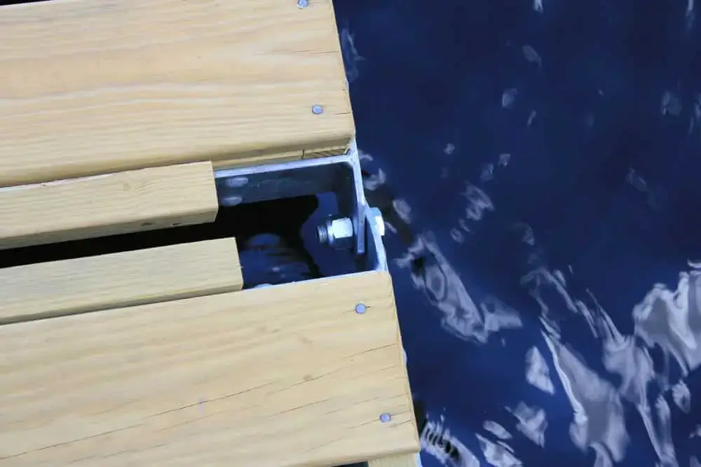Close-up of a Reinforced Hinge Plate by Great Northern Docks, with metal bolts on light wood planks, showcasing quality Maine Docks craftsmanship.