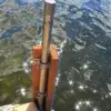 A close-up of a Corner Rail Bracket from Great Northern Docks attached to wooden planks, with sunlight reflecting off the water in the background.
