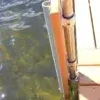 A close-up of a Great Northern Docks edge featuring Rail Brackets and metal poles, stretching into clear water with visible rocks below.