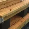 Close-up of stacked wood docks with metal brackets, supported on black plastic floats—featuring the T-Hinge Plate.