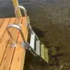 The Aluminum Dock Ladder is ideal for Maine docks, descending from a wood dock into clear, shallow water with a sandy and rocky bottom.