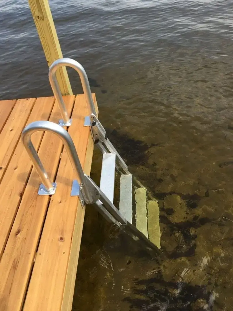 The Aluminum Dock Ladder is ideal for Maine docks, descending from a wood dock into clear, shallow water with a sandy and rocky bottom.