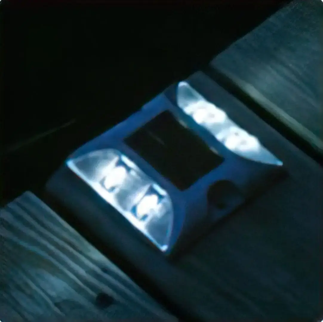 The Solar Deck Light is a solar-powered LED that emits blue light at night, installed between wooden planks on Maine Docks.