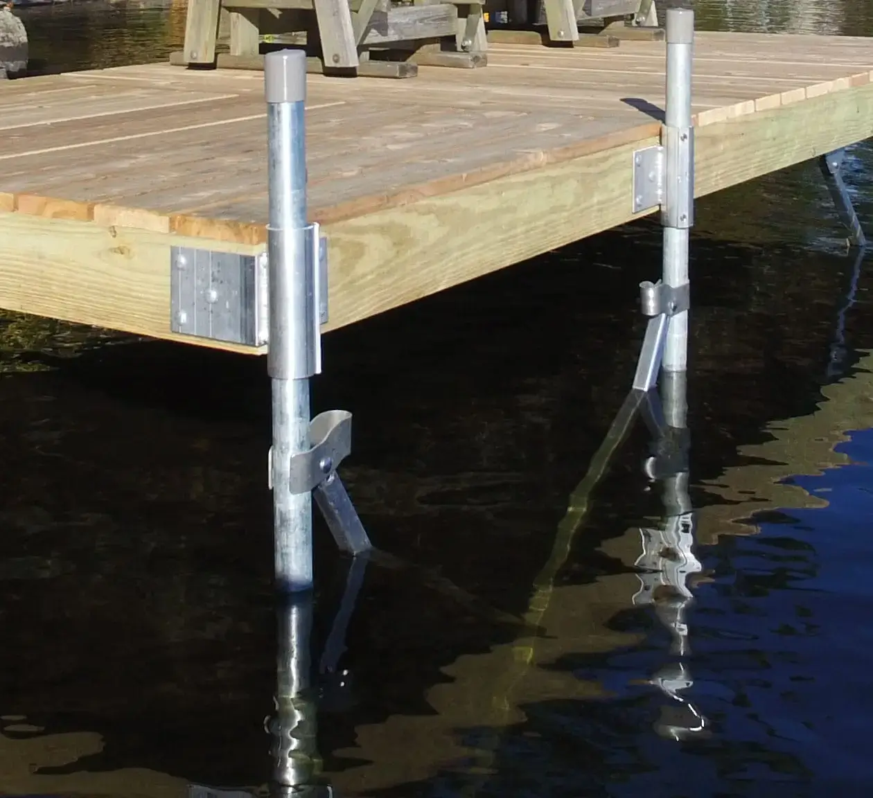 Close-up of Maine docks with metal supports in water, featuring a chair atop the dock secured with the Galvanized Carriage Bolt Attachment Kit.