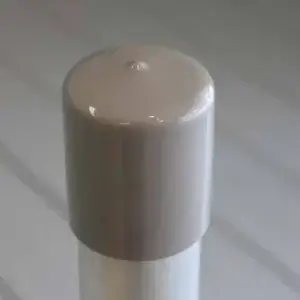 A close-up of a beige Pipe Safety Cap (6 Pack) from Great Northern Docks on a metal post, set against a blurred striped background.