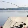 Two Mooring Whip (2 Pack) units are set up on a boat with a tarp, facing a calm lake and trees near Maine Docks under a clear sky.