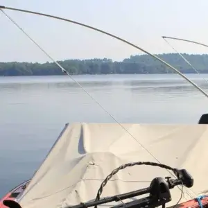 Two Mooring Whip (2 Pack) units are set up on a boat with a tarp, facing a calm lake and trees near Maine Docks under a clear sky.