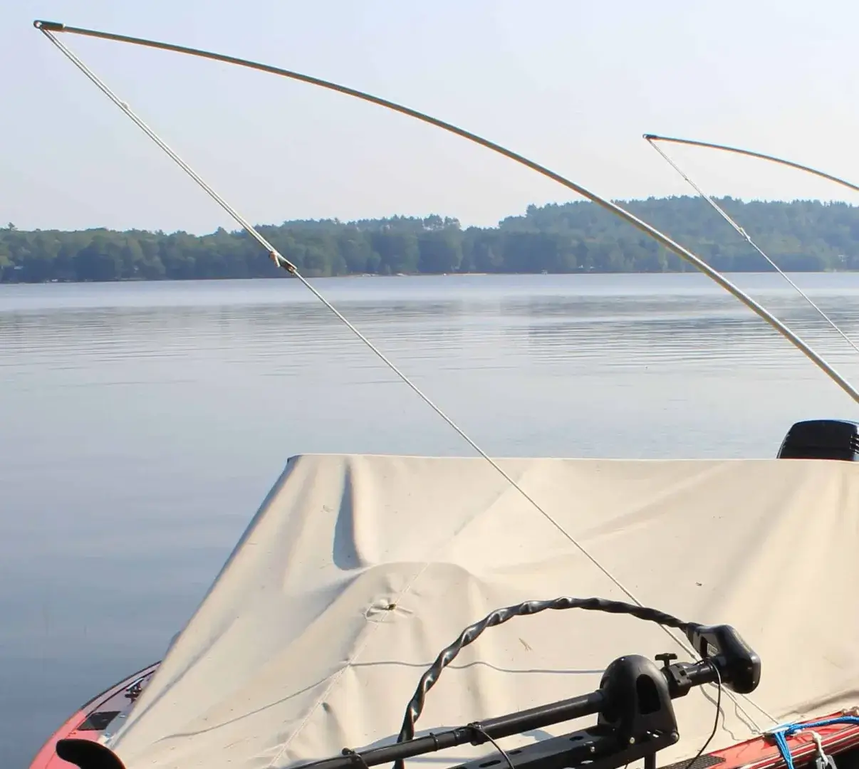 Two Mooring Whip (2 Pack) units are set up on a boat with a tarp, facing a calm lake and trees near Maine Docks under a clear sky.