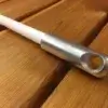 A white Mooring Whip (2 Pack) with a metal-tipped large hole lays diagonally on wood, reflecting classic Maine dock craftsmanship.