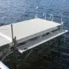 The Boarding Steps by Great Northern Docks extends over the water with a ladder, supported by posts and featuring a bench on one side.