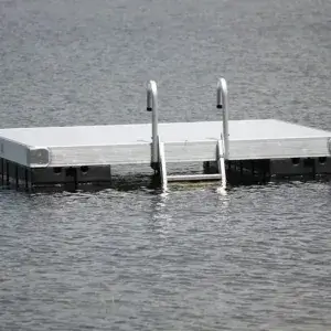 A Maine Docks Swim Raft with a ladder floats on calm water, anchored and empty, showcasing the quality craftsmanship of their products.