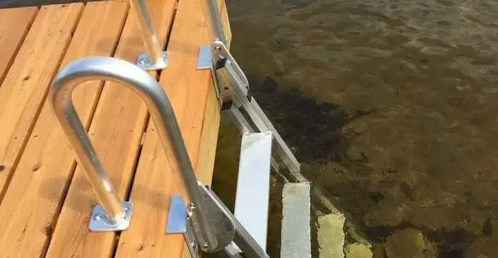 A dock ladder is installed, but its last step is too high above the water, making it difficult to access the lake from the dock.
